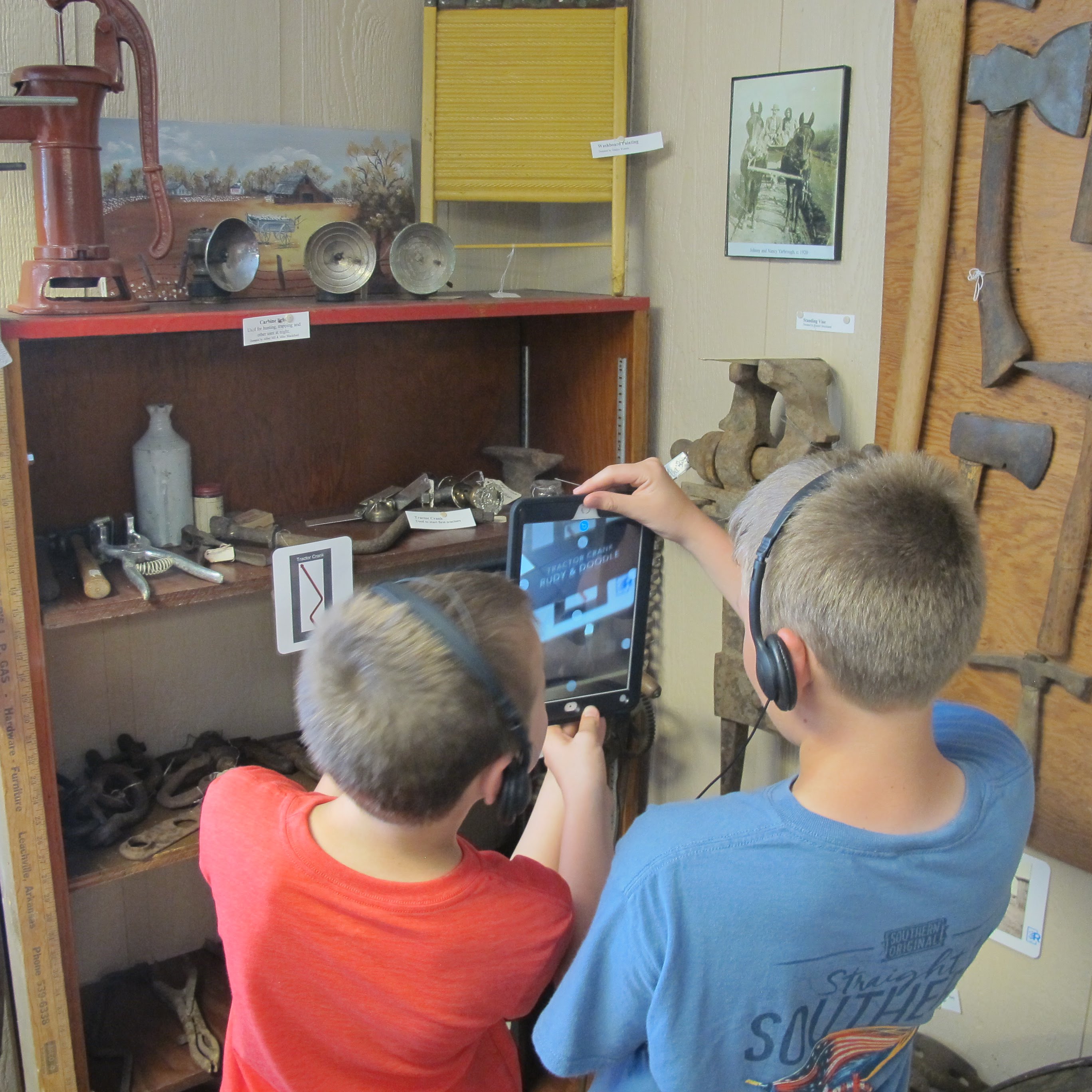 Kids using iPads in Museum exhibition to view augmented reality videos.