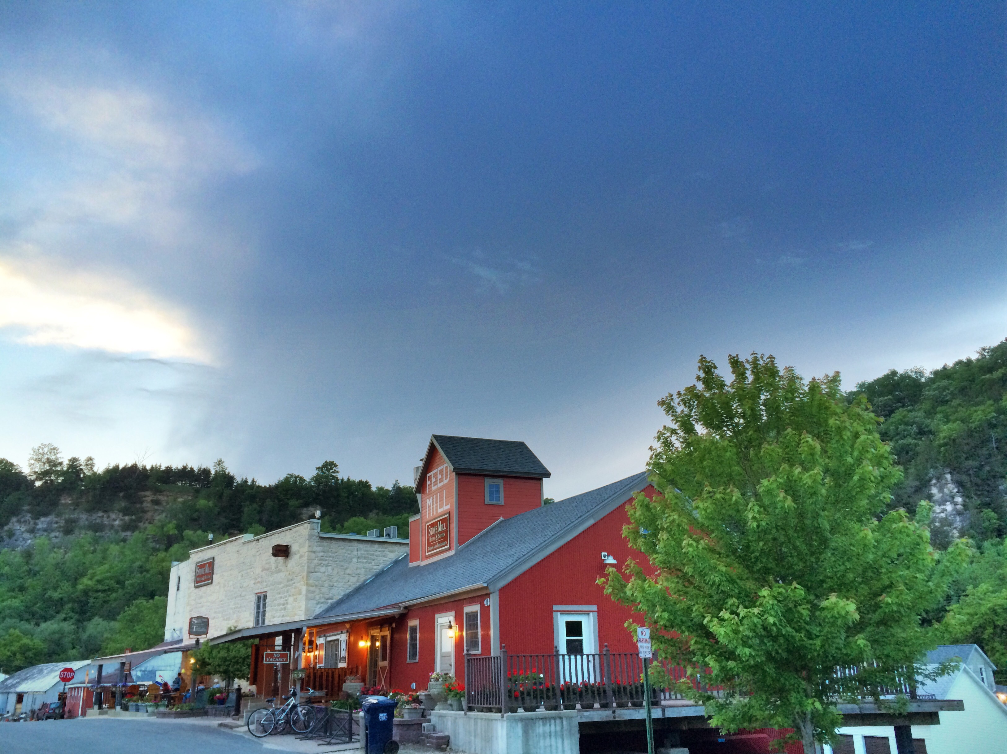 A view of Main Street in downtown Lanesboro shows a red barn-like building and bicycles parked in front.