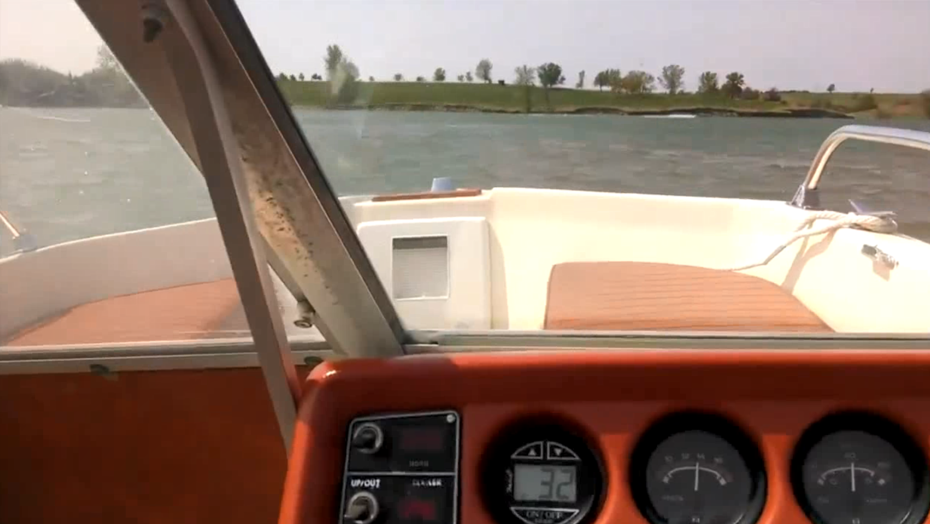 The dashboard equipment on a vintage boat as it sails along in the water.