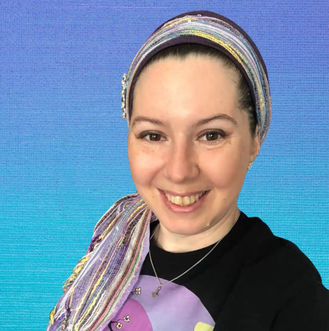 A woman with a striped scarf around her head and black t-shirt stands in front of a blue background.
