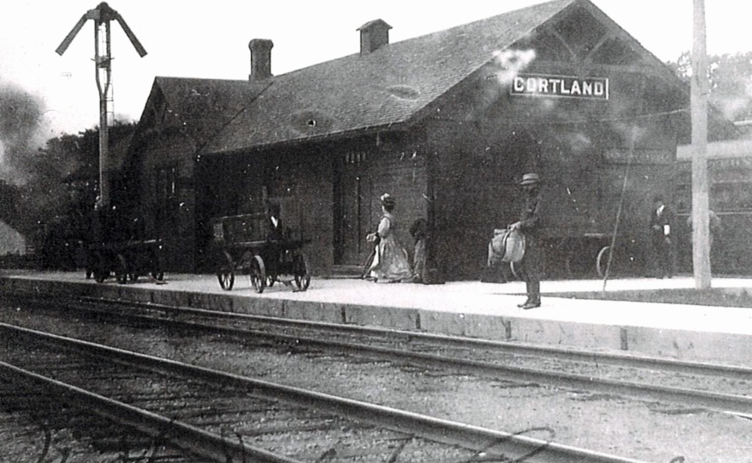 A view of vintage railroad depot in Illinois shows people on the platform.