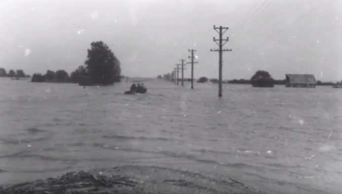 Historic rural flooding shown in a vintage black-and-white photo.