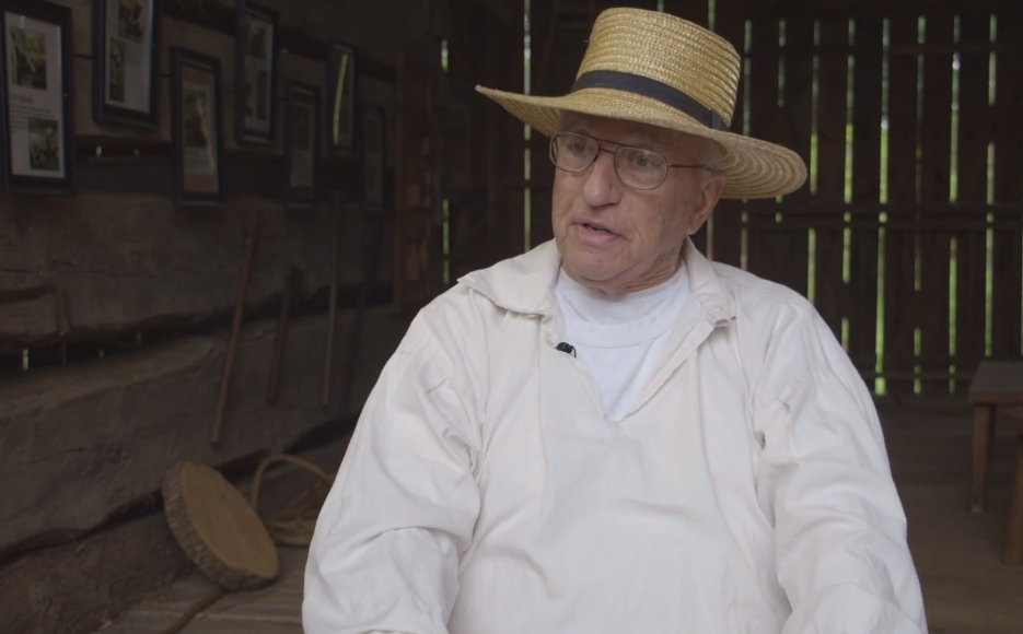 A man in 18th-century period clothing talks about the creation of the Hoff Barn.