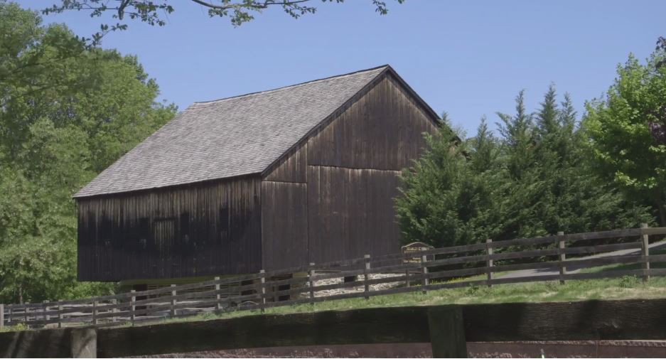 A historic wooden barn in an idyllic farm setting in summer. 