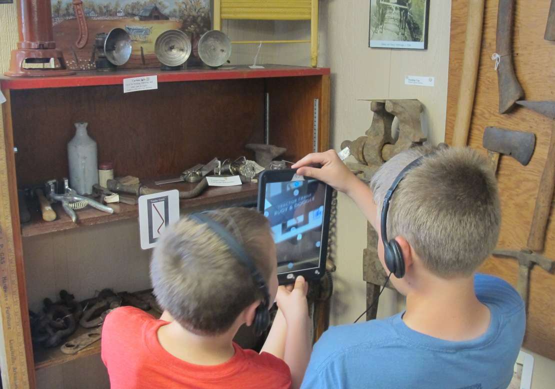 Kids using iPads in Museum exhibition to view augmented reality videos. Kids using iPads in Museum exhibition to view augmented reality videos.