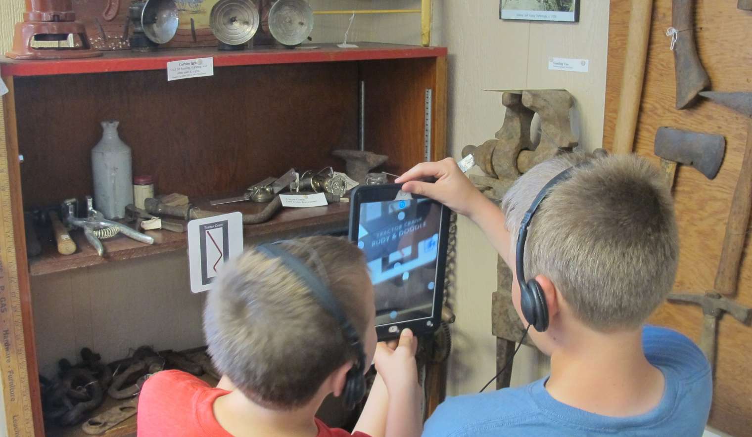 Kids using iPads in Museum exhibition to view augmented reality videos. Kids using iPads in Museum exhibition to view augmented reality videos.