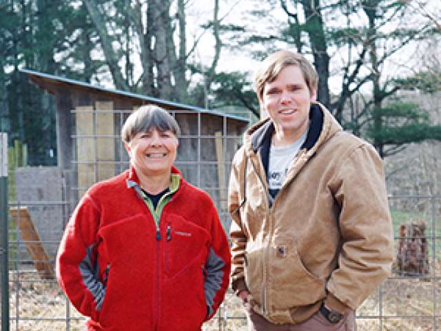 Both wearing jackets, Carol and Dave on the farm. 