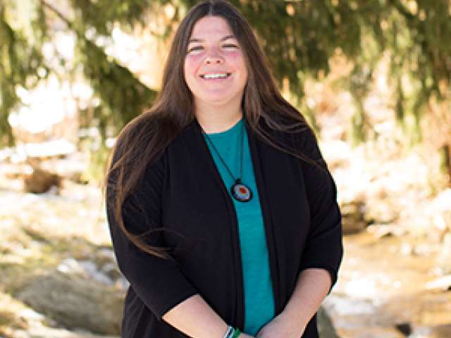 Jennifer Maxwell photographed underneath a canopy of trees.