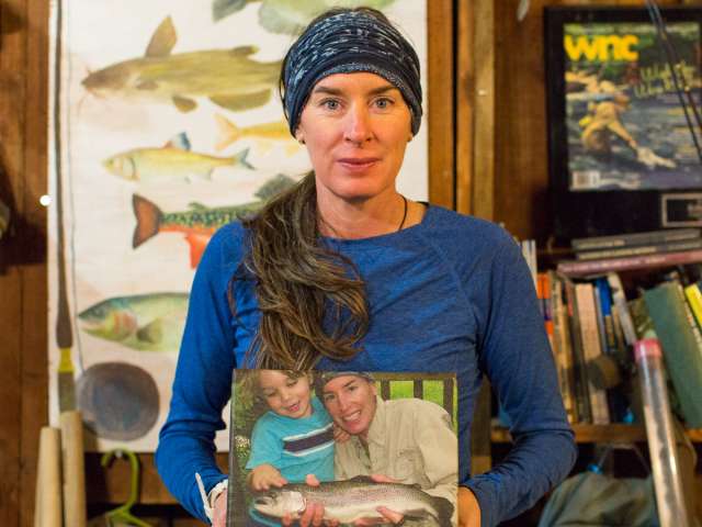 Kelly McCoy, holding a photo of her and her son fishing. 