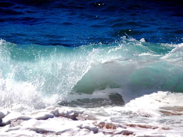 Waves crash down on a beach. Pexels stock photo