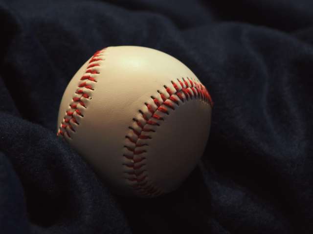 A white baseball is wrapped in a blue jacket. Pexels stock photo.