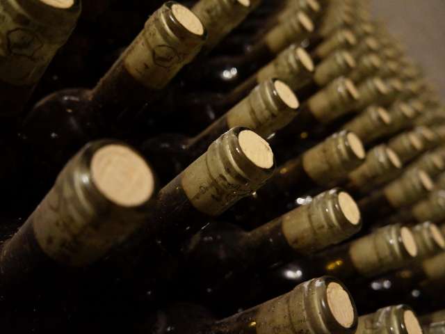 Dozens of wine bottles on a wall. Pexels stock photo.