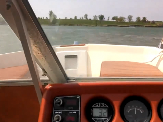 The dashboard equipment on a vintage boat as it sails along in the water.