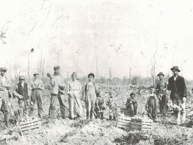 A black-and-white drawing of people in vintage clothes standing in a field.