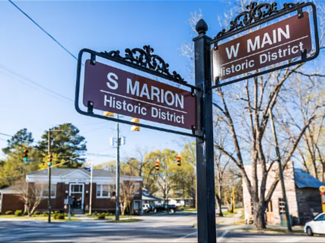 A corner street sign in South Carolina with the cross streets, S Marion and W Main. 