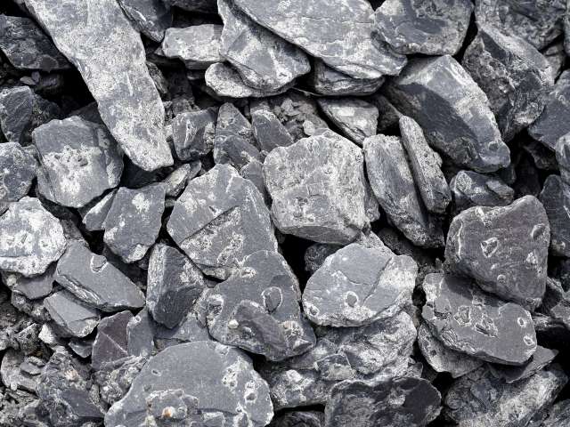 A pile of dark gray, slate-type rocks. 