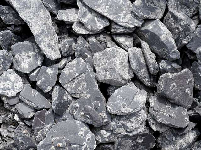 A pile of dark gray, slate-type rocks.