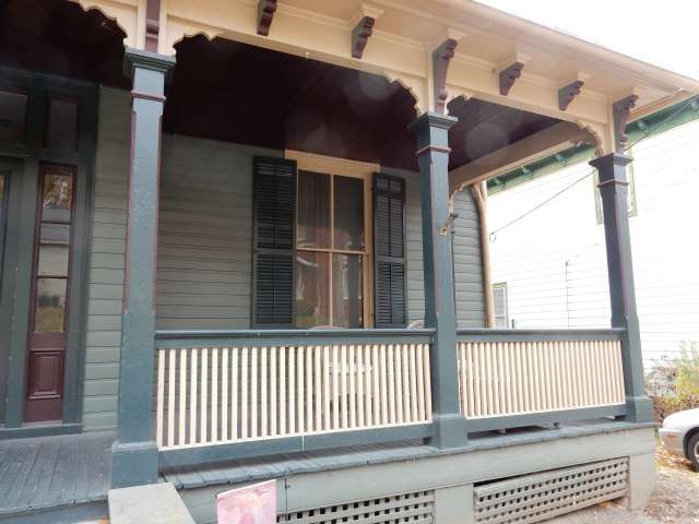 The front porch of historic house, painted in white and blue.