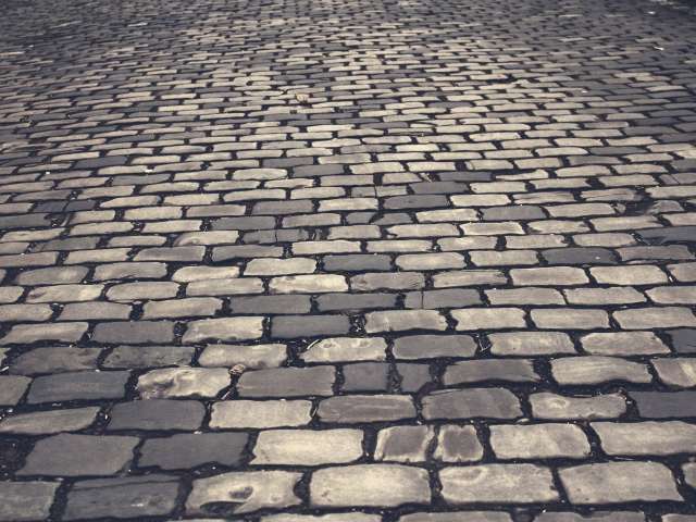 Gray cobblestones line an old street. 