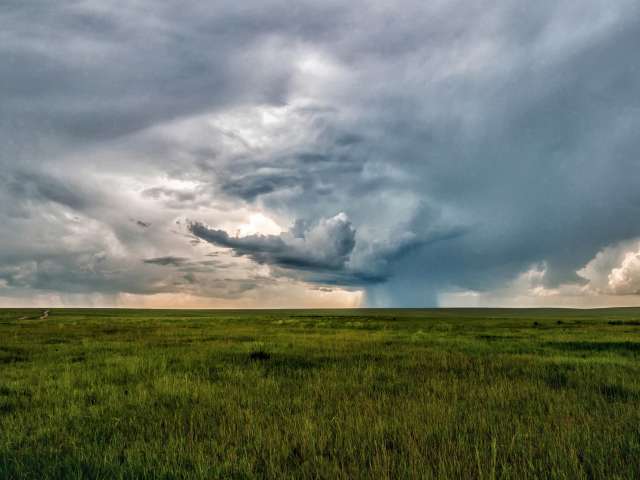 Serious story clouds roll over fields in the midwest. 