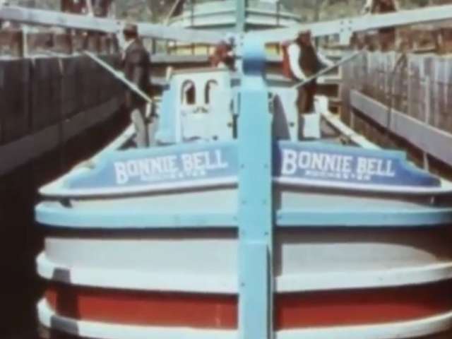 A vintage photo of an old boat going through the Erie Canal.