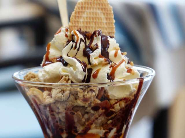 A delcious ice cream sundae in a tall glass.