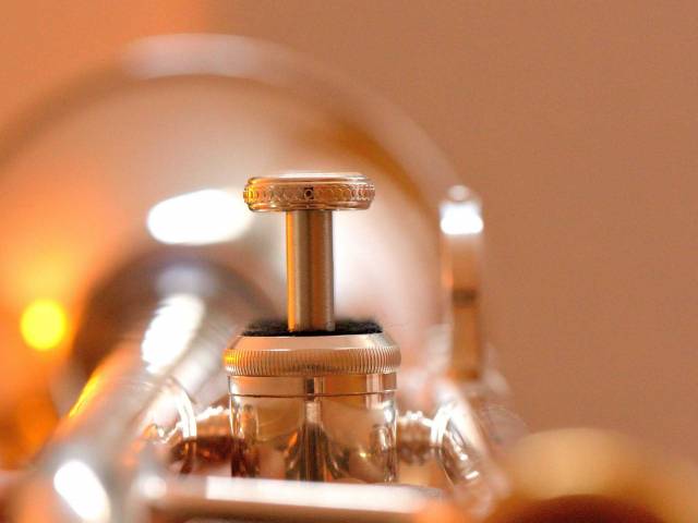A close-up view of a brassy trumpet's valves. 