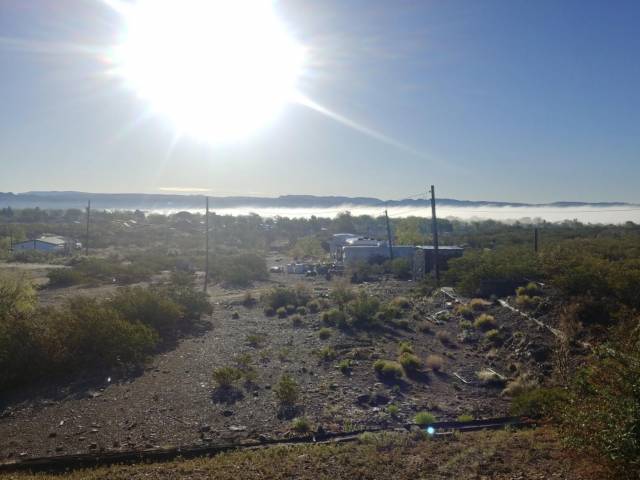 A view of a few houses in a New Mexico desert as the sun shines down. 