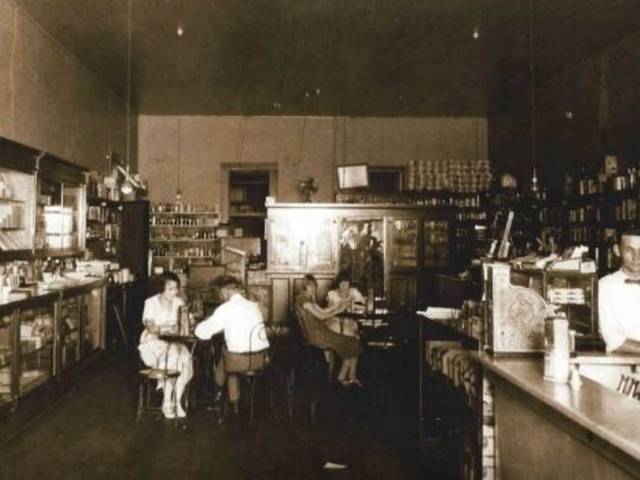 Vintage image of a general store or soda counter in the early 20th century.