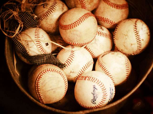 A basket full of vintage baseballs.
