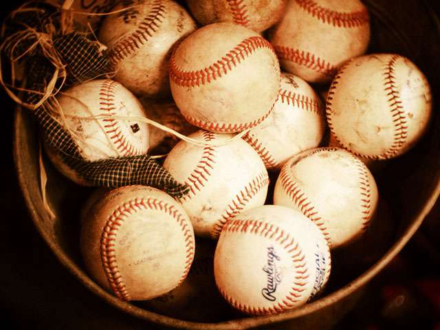 A basket full of vintage baseballs. 