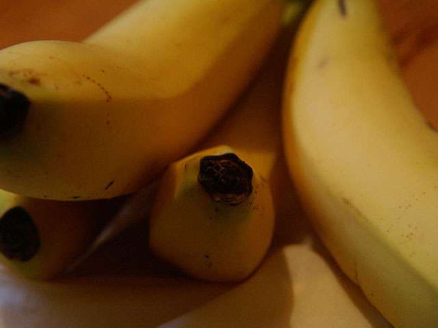 The ends of a bunch of ripe bananas. 