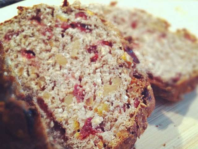 An image of dense bread or cake with nuts and various berries.