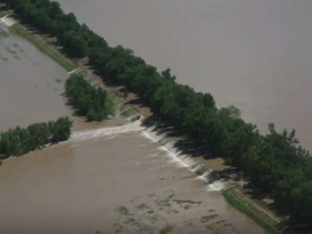 A roadway appears to be completely washed out in an aerial view of a flat land mass. 