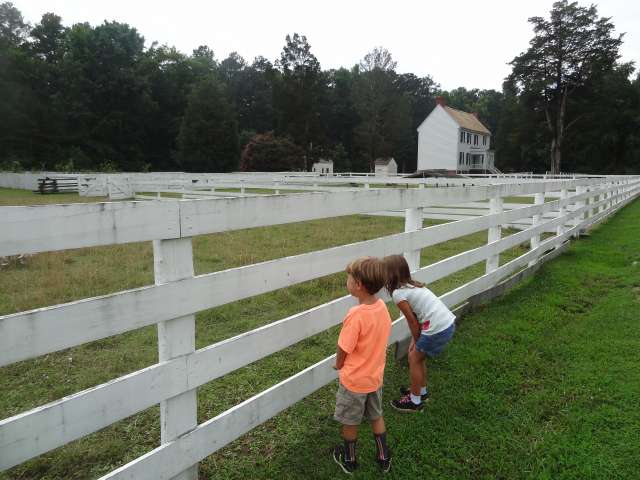 Children look through a fence in a small American town.