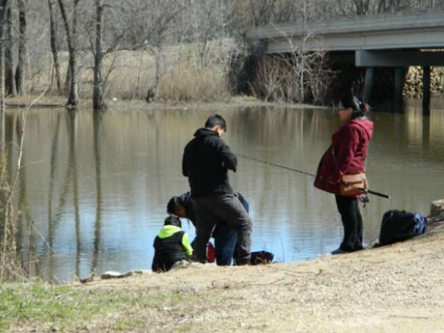Tom Chang and his family stand on the bank of a river, getting ready to cast.