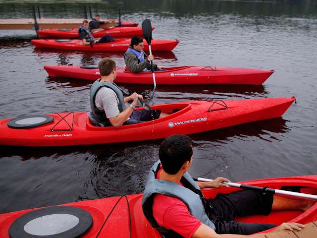 A group of kayakers wait by a dock. Pexels stock image