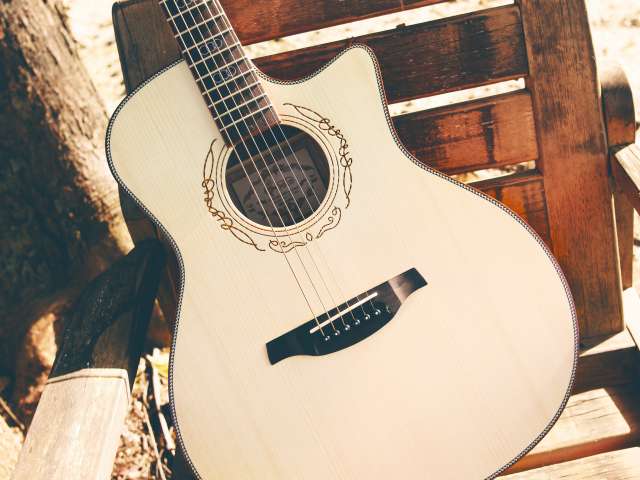 A classic guitar sitting on a chair. Pexels stock photo