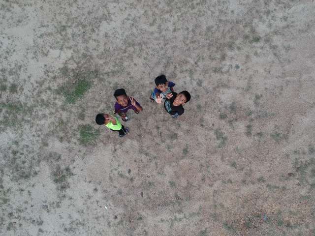 A group of small children making peace signs, as photographed from above. Pexels stock photo
