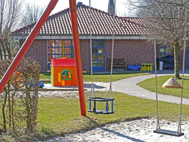 A playground with a plastic playset and swings. Pexels stock photo