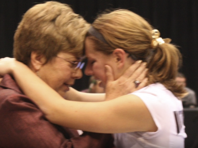 A coach leans her head into to talk to a player. 